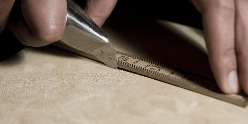 Angedeuterer Schnitt mit einem Cuttermesser für eine Velourlederfliese.