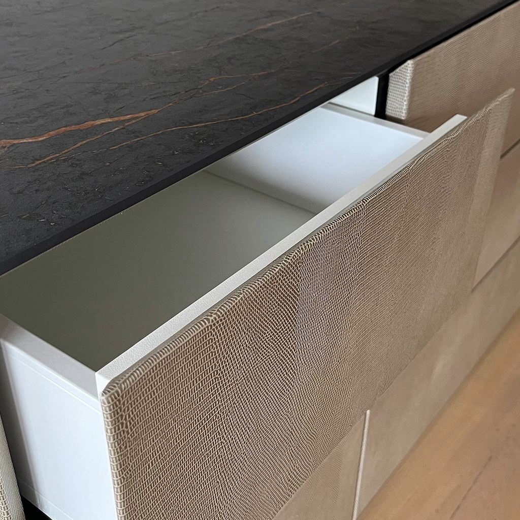 Close-up of a drawer lined in snakeskin-embossed leather.