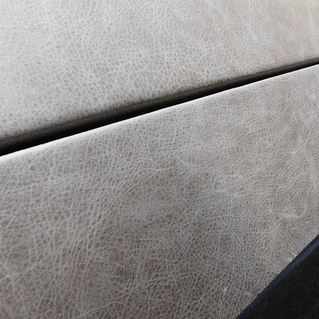 Custom leather flooring and two-tone leather wall paneling in gray and black suede.