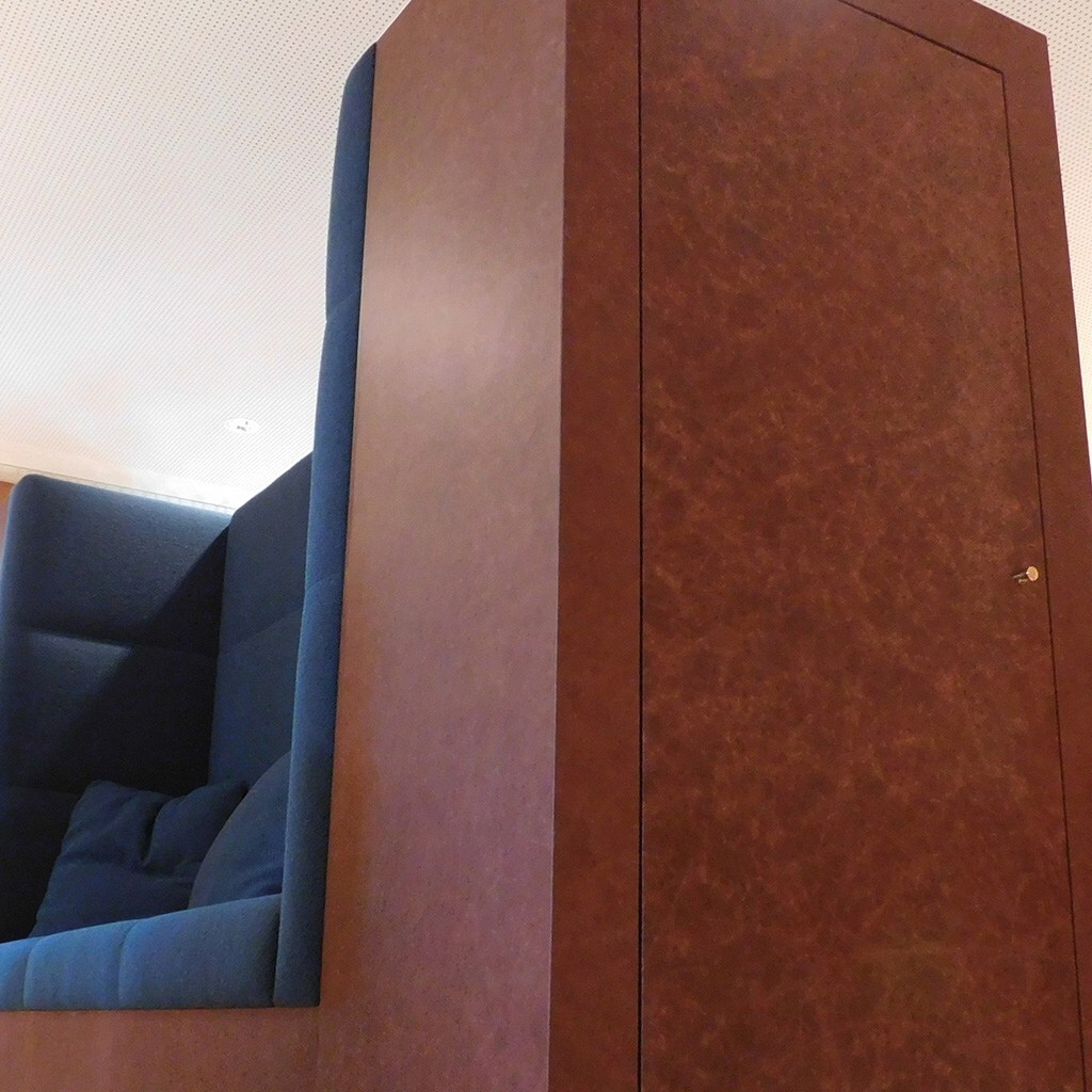 Cabinet and bench upholstered in brown leather.