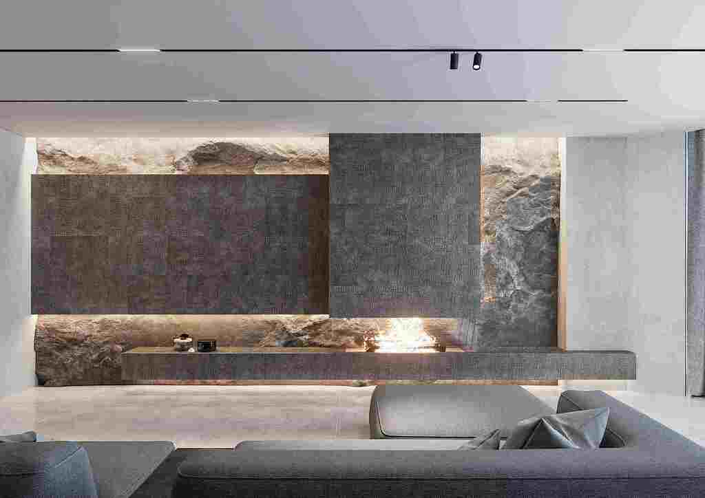 Living room with a fireplace paneled in embossed caiman-pattern leather.