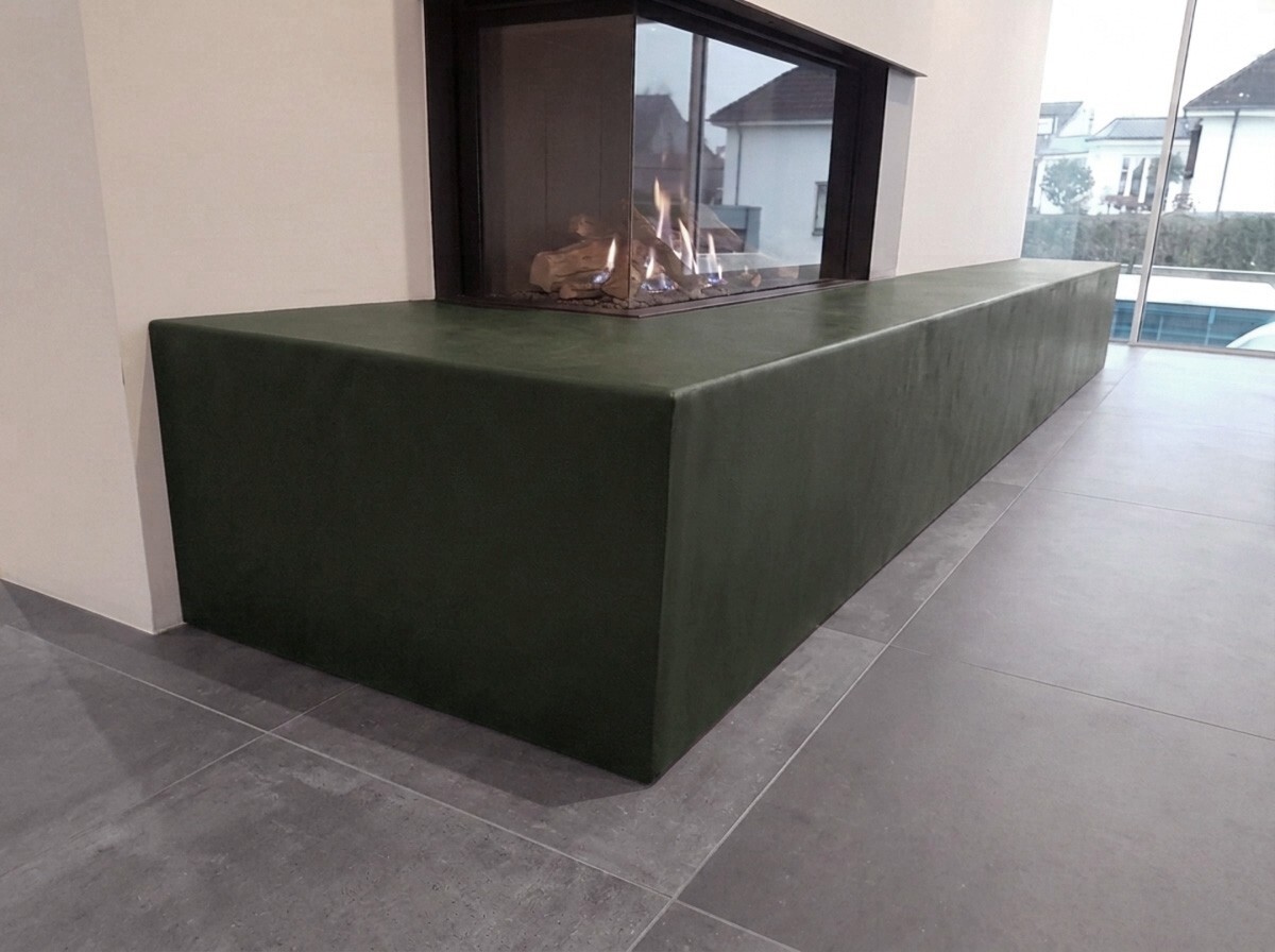 Modern fireplace completely clad in green leather.