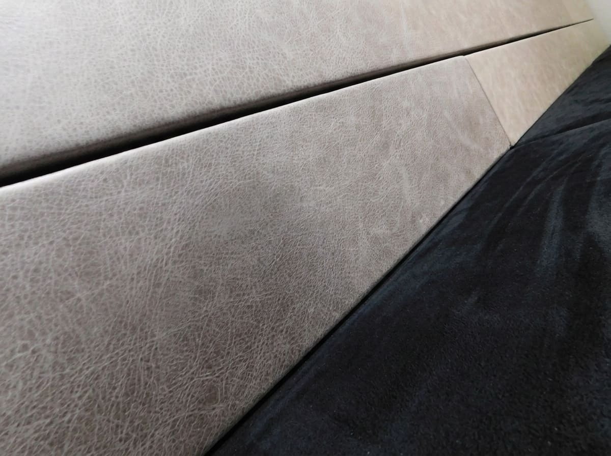 Close-up detail of a bench upholstered in a combination of suede and gray genuine leather.
