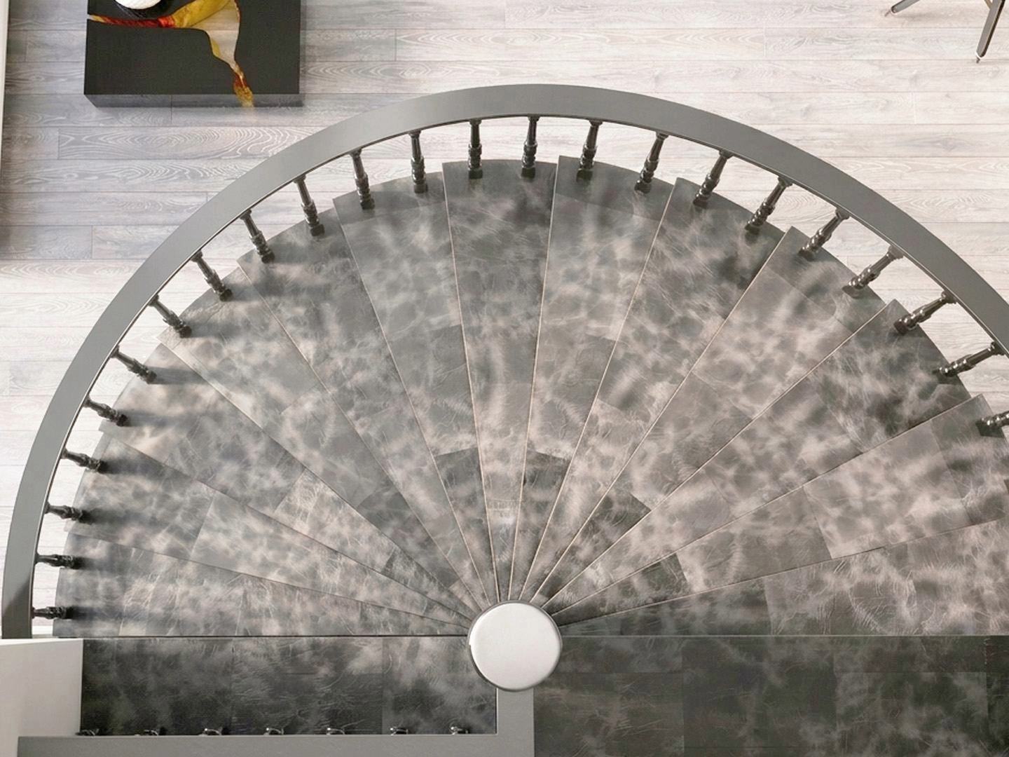 Spiral staircase with stair treads in gray leather, shade Moonstone.
