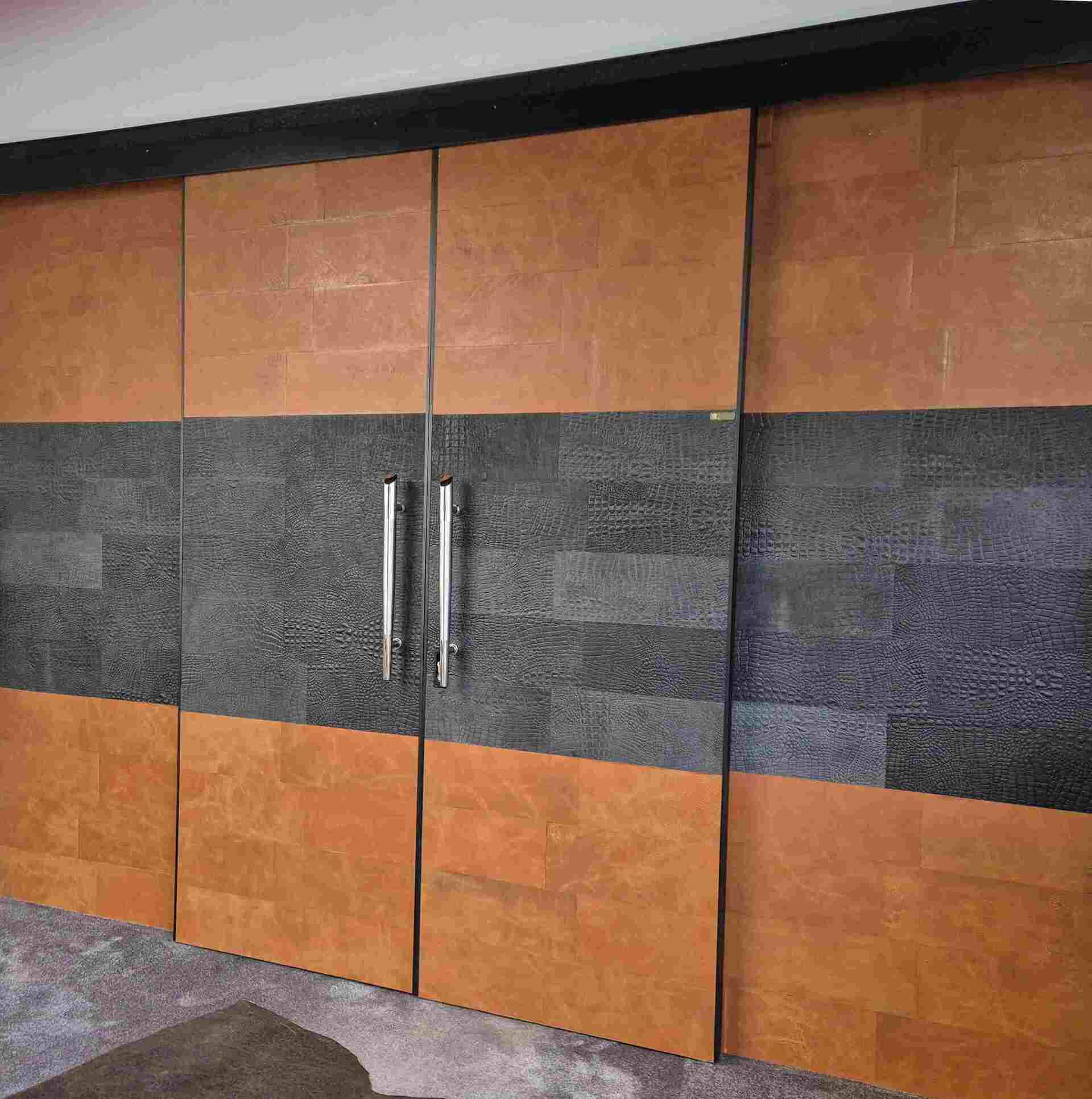 Leather sliding door paneled in two leather colors, entrance door to the leather flooring manufactory showroom.