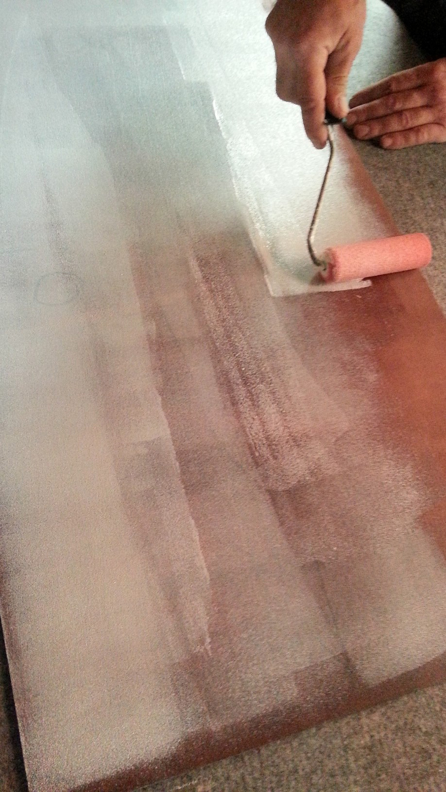 Manual adhesive application with a roller for leather tiles.